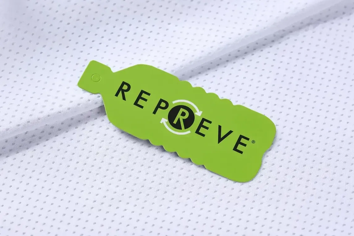 REPREVE recycled fabric tag resting on a white perforated polyester knit