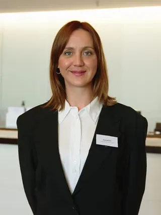 Hotel receptionist in formal uniform at front desk