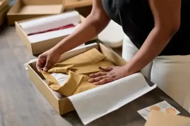 Custom clothing packaging being packed into a box