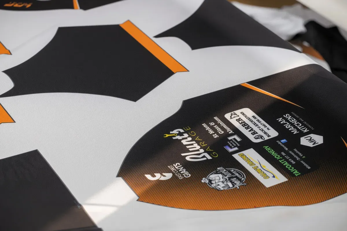 Close-up of a sublimation printed jersey showing crisp sponsor logos and strong colour hold