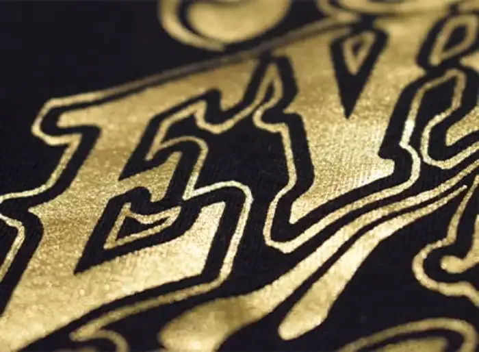 Gold foil screen print detailing on a black garment